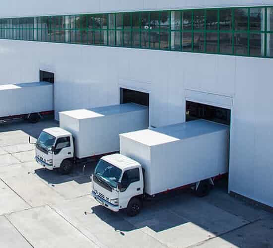 Three large white crate trucks